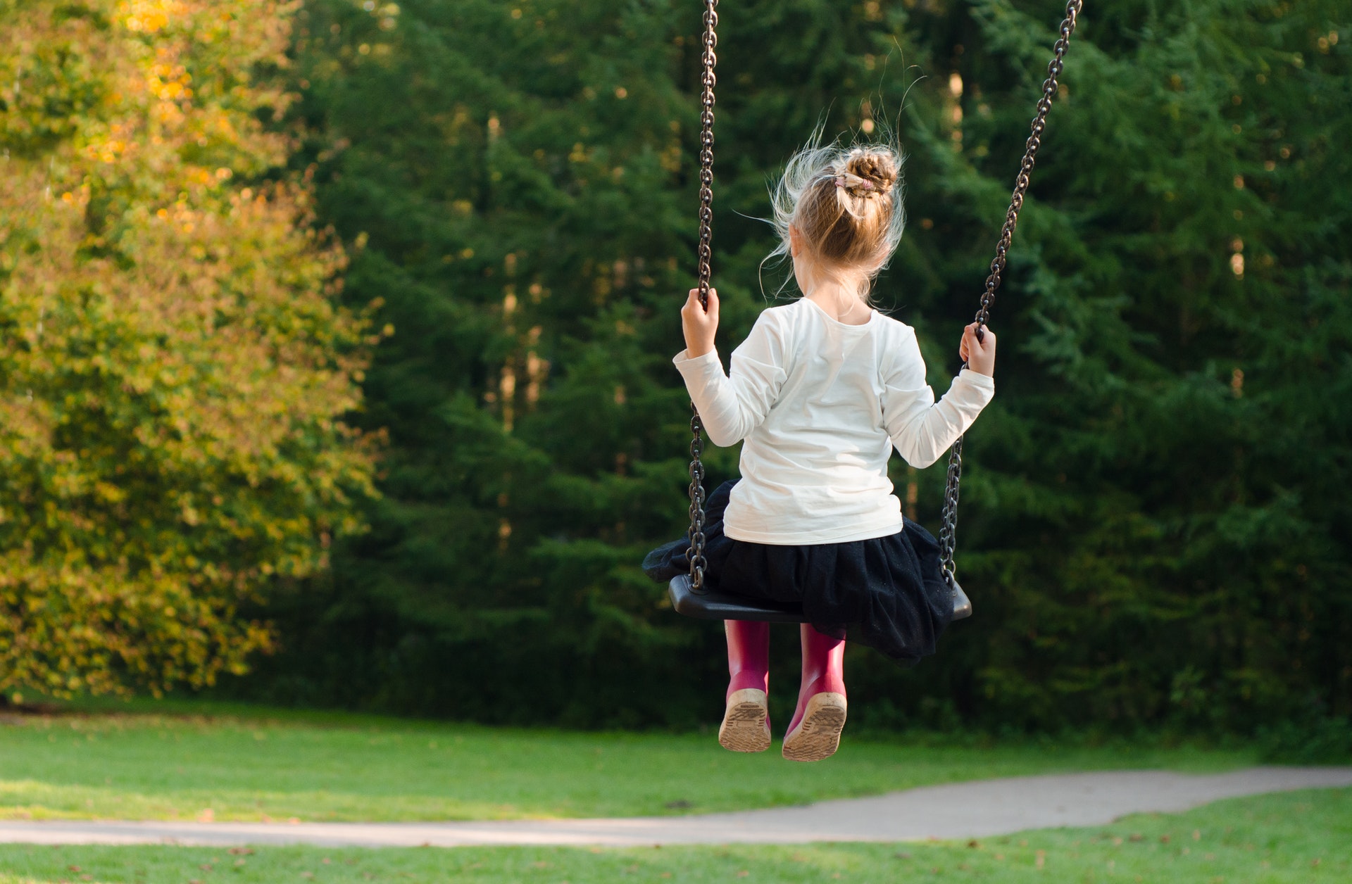 Little girl by herself on swing