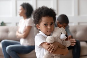 Portrait of upset little african child boy holding toy looking at camera, sad sensitive small mixed race kid feel lonely hurt suffer from family conflicts fights, parents divorce, children custody