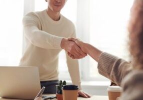 Man and woman shaking hands and saving on divorce costs